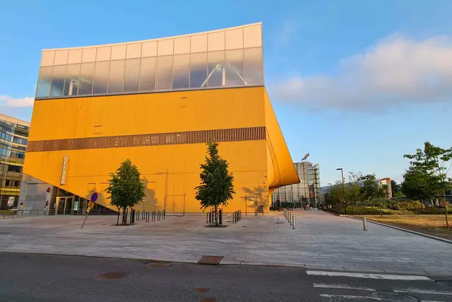 Geschwungene Holzfassade der Bibliothek Oodi in Helsinki im Abendlicht