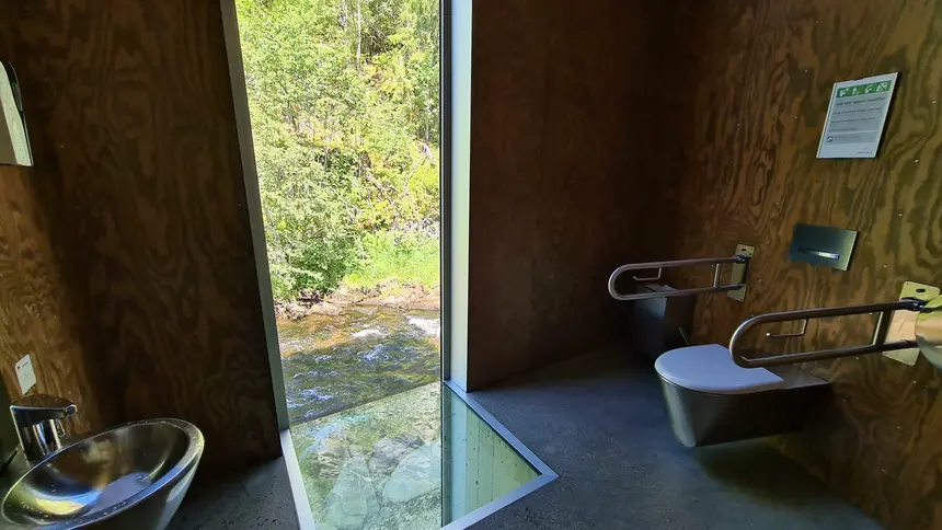 Toilettenraum am Skjervsfossen mit Glaswand und Glasboden über dem rauschenden Fluss