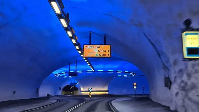 Blau beleuchteter Kreisverkehr im Vallaviktunnel mit Wegweisern nach Ulvik, Odda und Oslo