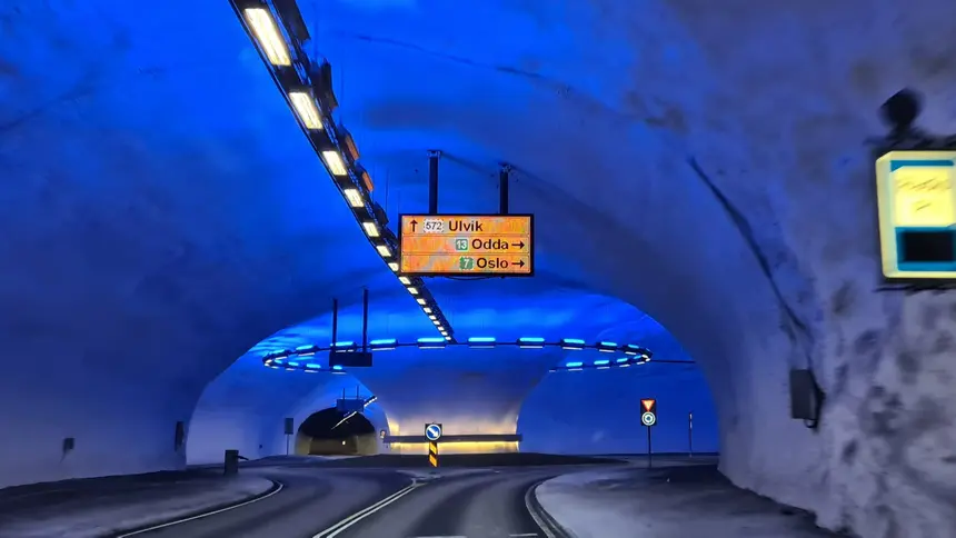 Blau beleuchteter Kreisverkehr im Vallaviktunnel mit Wegweisern nach Ulvik, Odda und Oslo