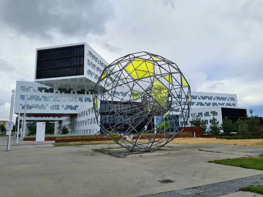 Kugelförmige Stahlgitter-Skulptur vor dem gestapelten Equinor-Gebäude bei Oslo