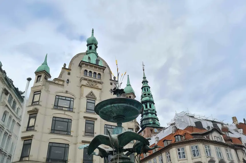 Storchenbrunnen auf Amagertorv an der Strøget mit grünen Kupfertürmen dahinter