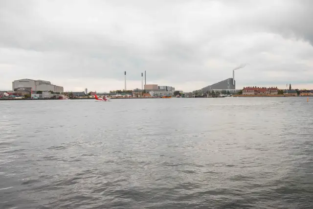 Kopenhagener Hafenpanorama mit Wasserflugzeug und dem Kraftwerk CopenHill