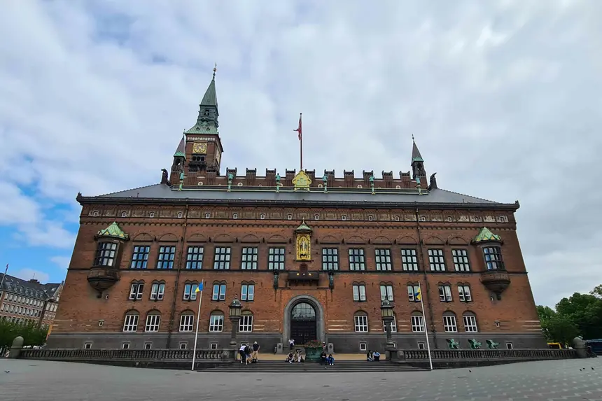 Backsteinfassade des Kopenhagener Rathauses mit Uhrturm und vergoldeter Figur