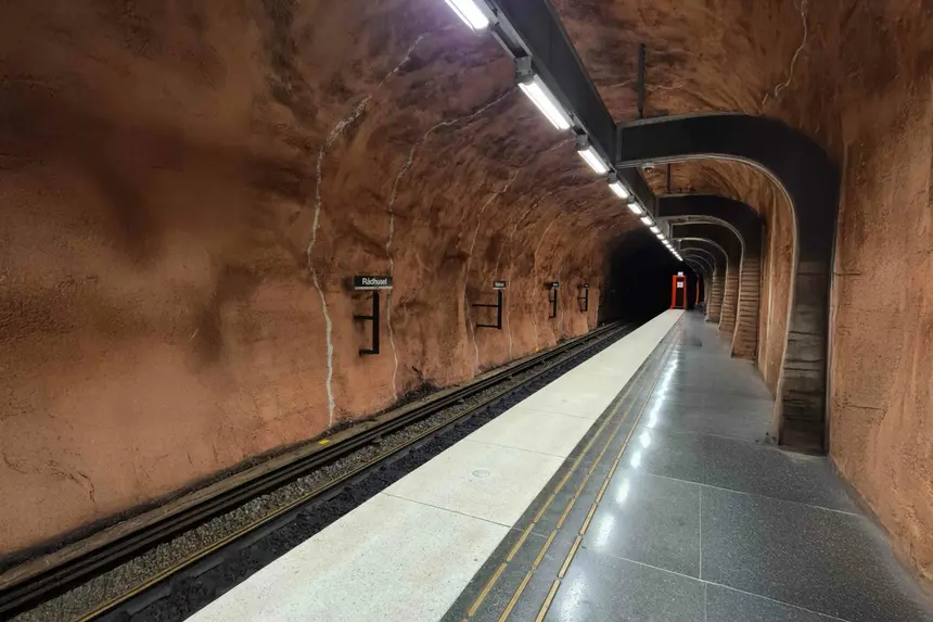 Leerer Bahnsteig der Station Rådhuset unter rostrotem Felsgewölbe