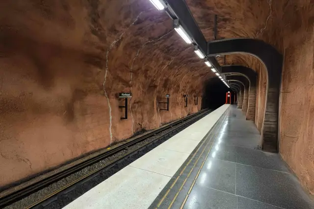 Leerer Bahnsteig der Station Rådhuset unter rostrotem Felsgewölbe