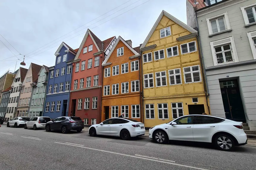 Bunte Giebelhäuser in Blau, Rot, Orange und Gelb entlang einer Kopenhagener Straße