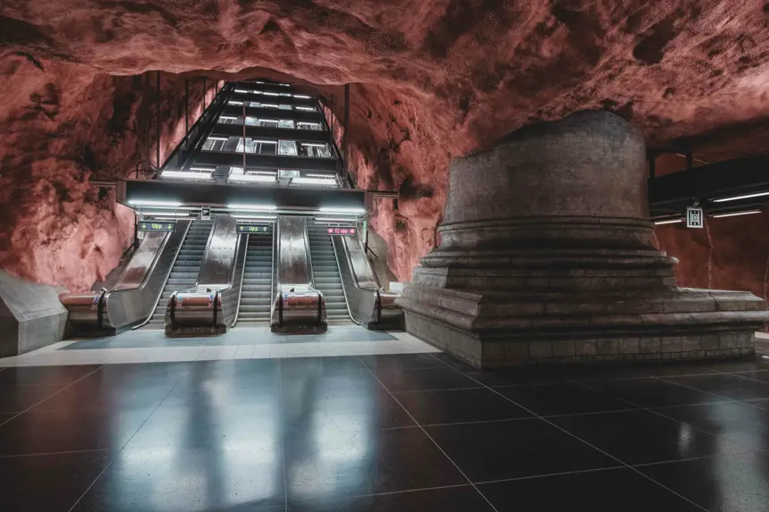 Rolltreppen führen aus der rot angestrahlten Felsenhalle der Station Rådhuset nach oben