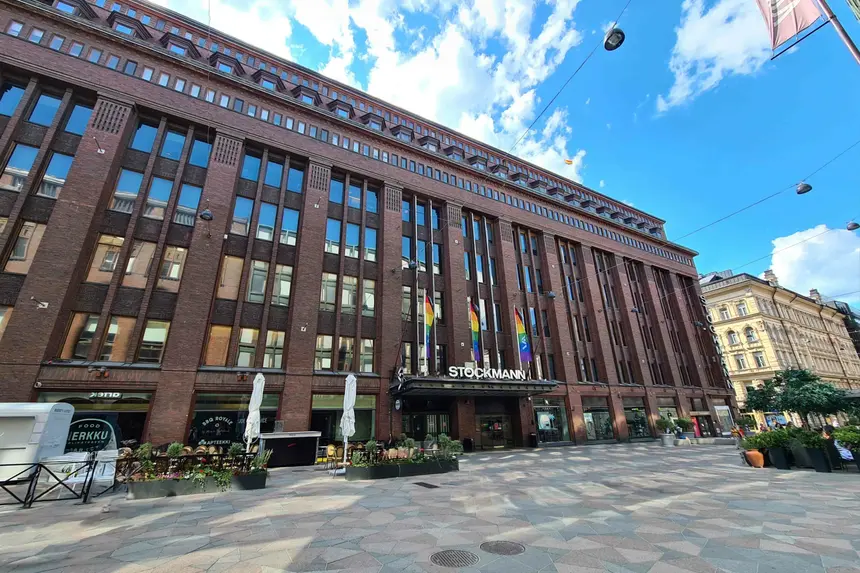Backsteinfassade des Kaufhauses Stockmann mit Regenbogenflaggen über dem Eingang