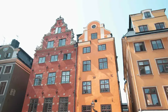 Rote und orange Giebelhäuser mit weißen Stuckornamenten am Stortorget in Gamla Stan