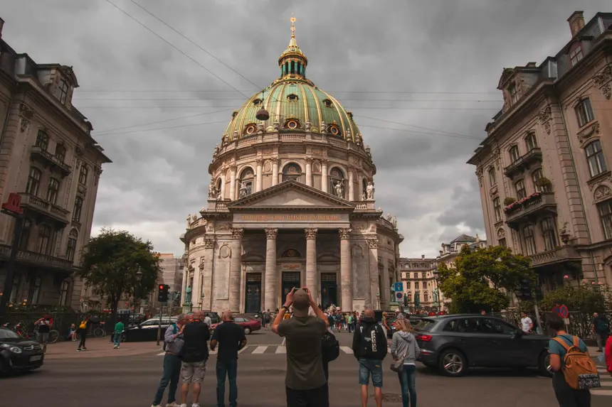 Die grün-goldene Kuppel der Marmorkirche in Kopenhagen unter dramatischen Wolken