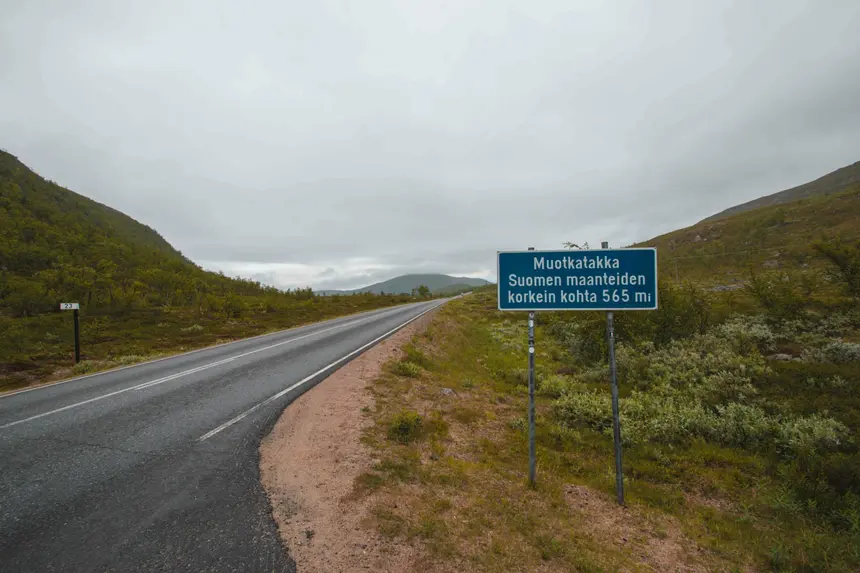 Blaues Straßenschild von Muotkatakka, dem höchsten Punkt der finnischen Straßen, zwischen Fjellhängen