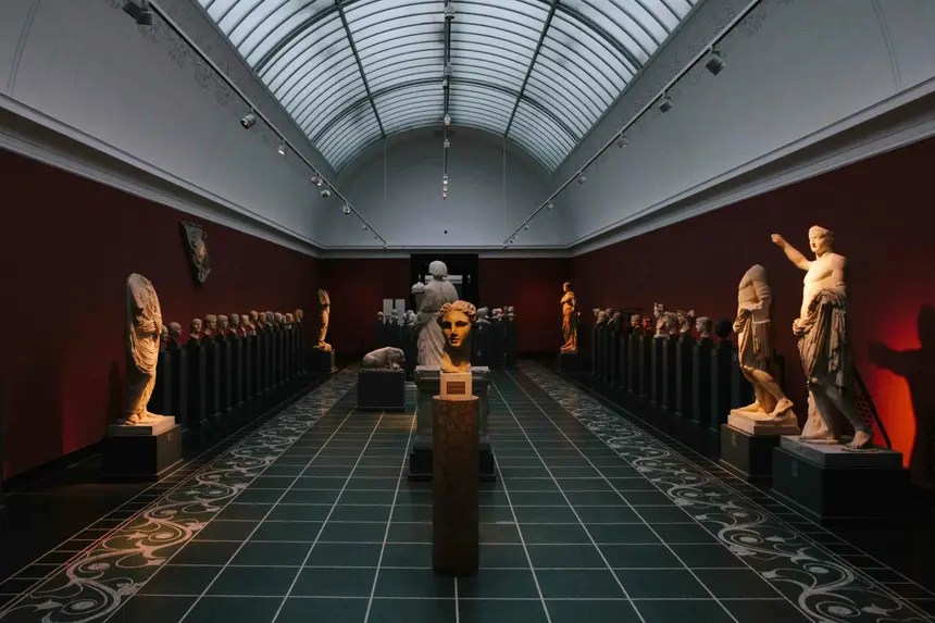Antike Statuen und Büstenreihen im stimmungsvoll beleuchteten Saal der Ny Carlsberg Glyptotek