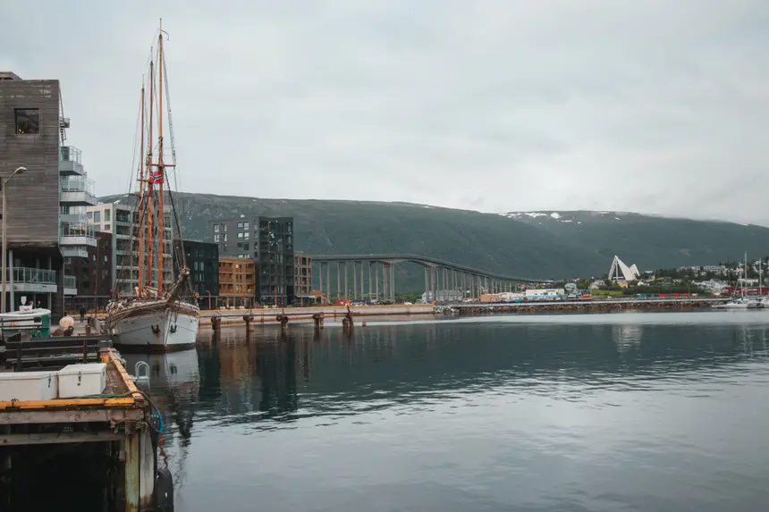 Historischer Segler mit Norwegenflagge am Kai von Tromsø, hinten Brücke und Eismeerkathedrale