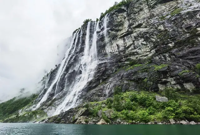 Der Wasserfall Sieben Schwestern stürzt über die Felswand in den Geirangerfjord