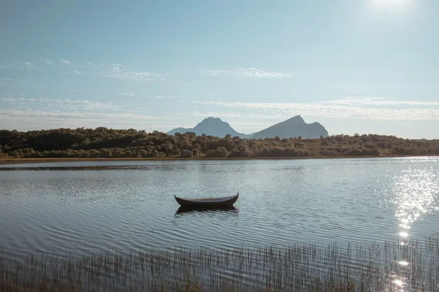 Traditionelles Holzruderboot auf spiegelglattem Wasser bei Leknes