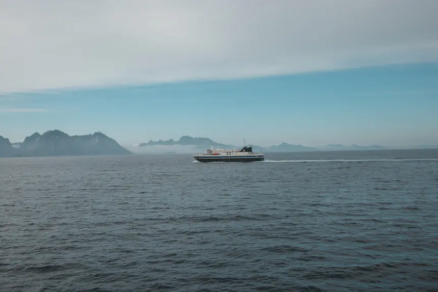 Fähre auf offener See vor der Bergkette der Lofoten