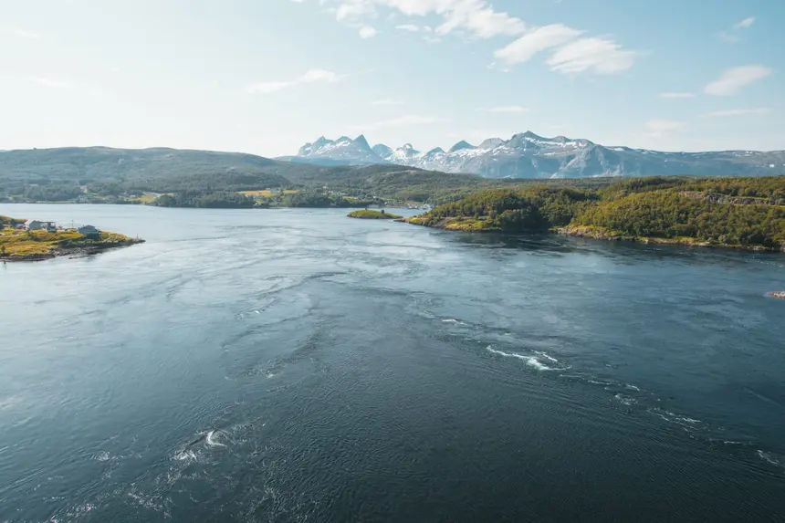Strudel und Wirbel des Saltstraumen vor schneebedeckten Gipfeln