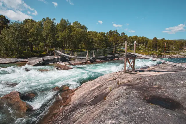 Hängebrücke Pont de Luonosjåhkå über tosenden türkisfarbenen Wildfluss