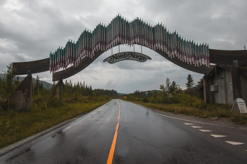 Nordlandsporten-Torbogen mit Nord-Norge-Schild über der regennassen E6