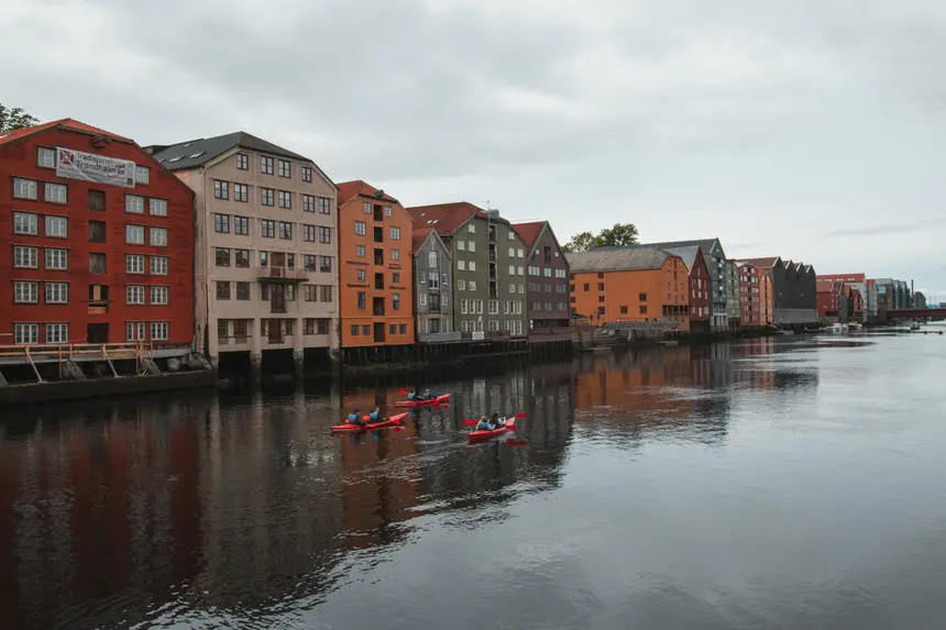 Rote Kajaks auf der Nidelva vor den Speicherhäusern von Trondheim