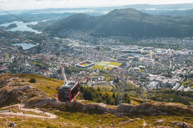 Rote Kabine der Ulriksbanen schwebt über Bergen mit Blick auf Stadt und Schären