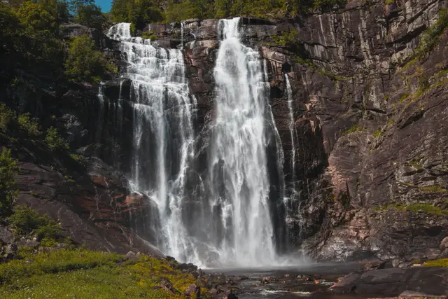 Der Skjervsfossen stürzt in breiten Kaskaden über eine dunkle Felswand
