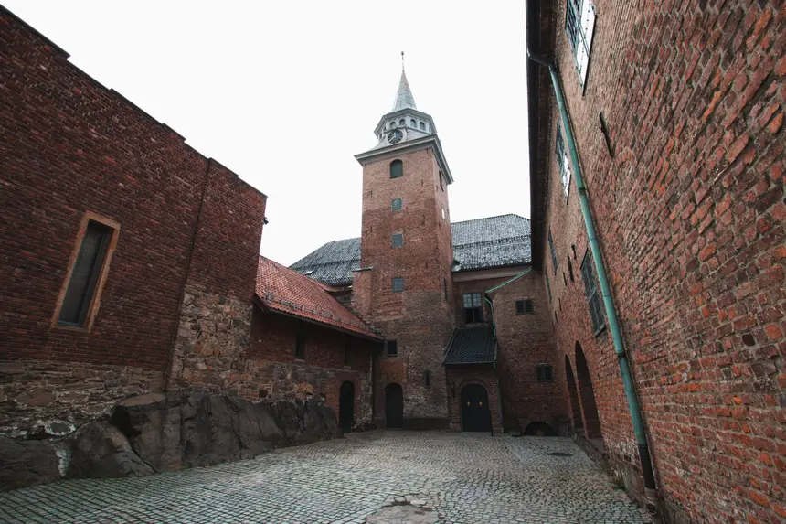 Gepflasterter Innenhof der Festung Akershus mit Backsteinmauern und Uhrturm