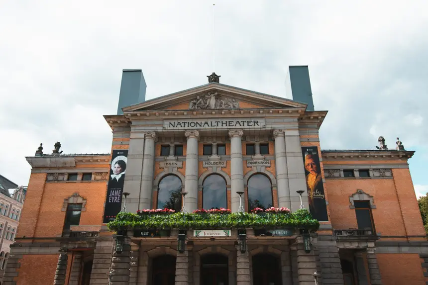 Fassade des Nationaltheaters in Oslo mit Säulen und blumengeschmücktem Balkon