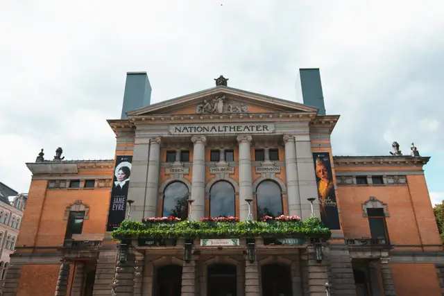 Fassade des Nationaltheaters in Oslo mit Säulen und blumengeschmücktem Balkon