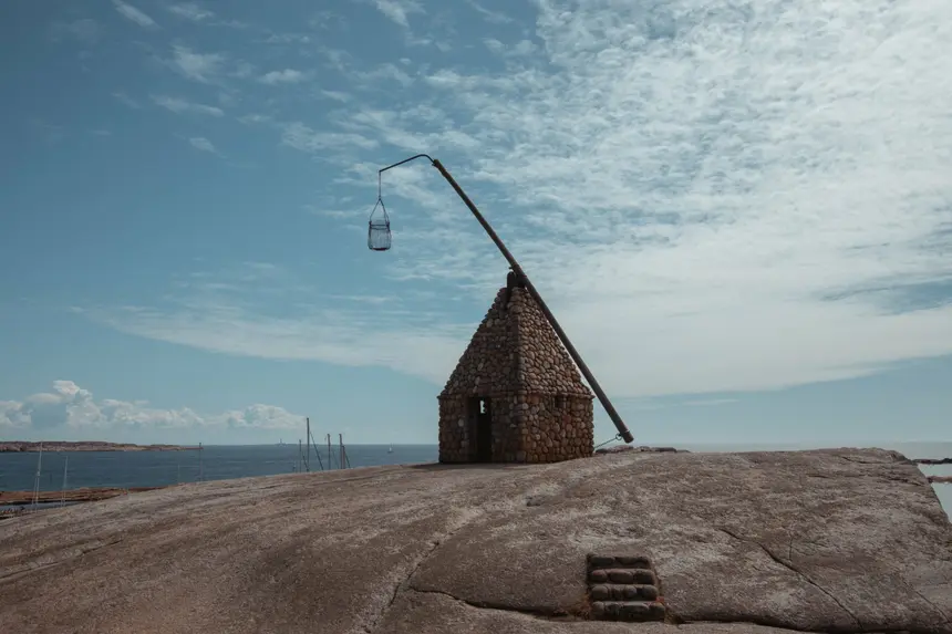 Steinerne Leuchtfeuerhütte mit schrägem Feuerkorb-Mast am World's End bei Tjøme