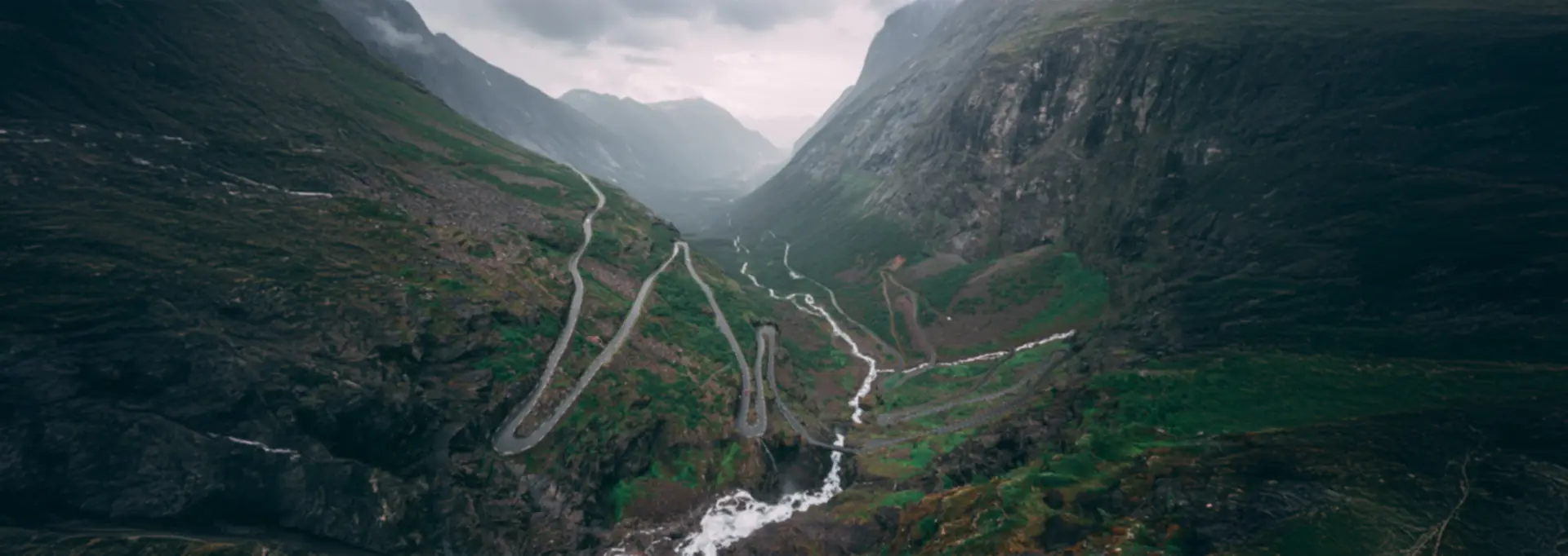 Serpentinen des Trollstigen schlängeln sich durch das neblige Tal