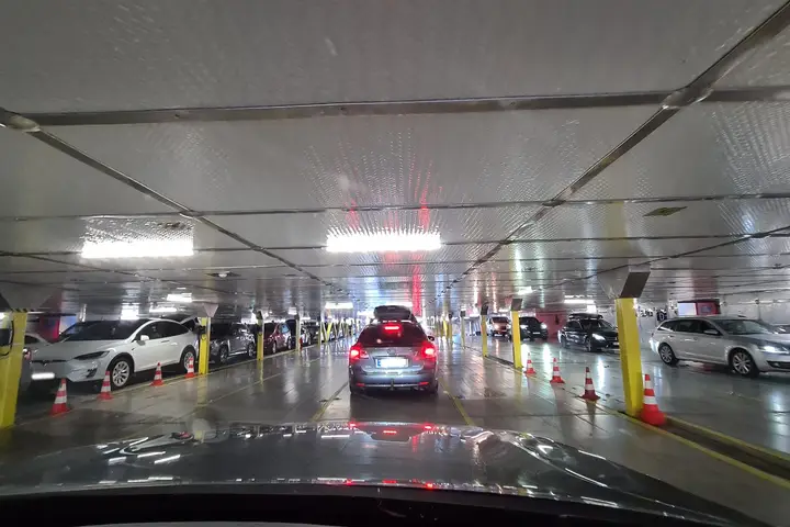 Dicht geparkte Autos auf dem beleuchteten Autodeck während der Einfahrt