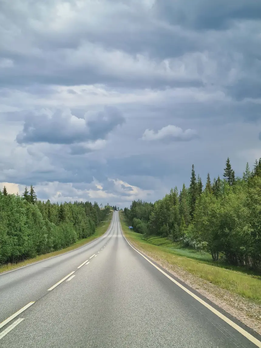 Schnurgerade Landstraße durch die endlosen Wälder Lapplands