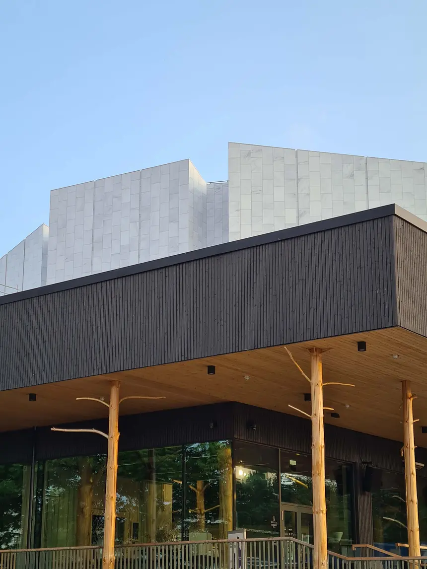 Die weiße Marmorfassade der Finlandia-Halle über dem hölzernen Anbau