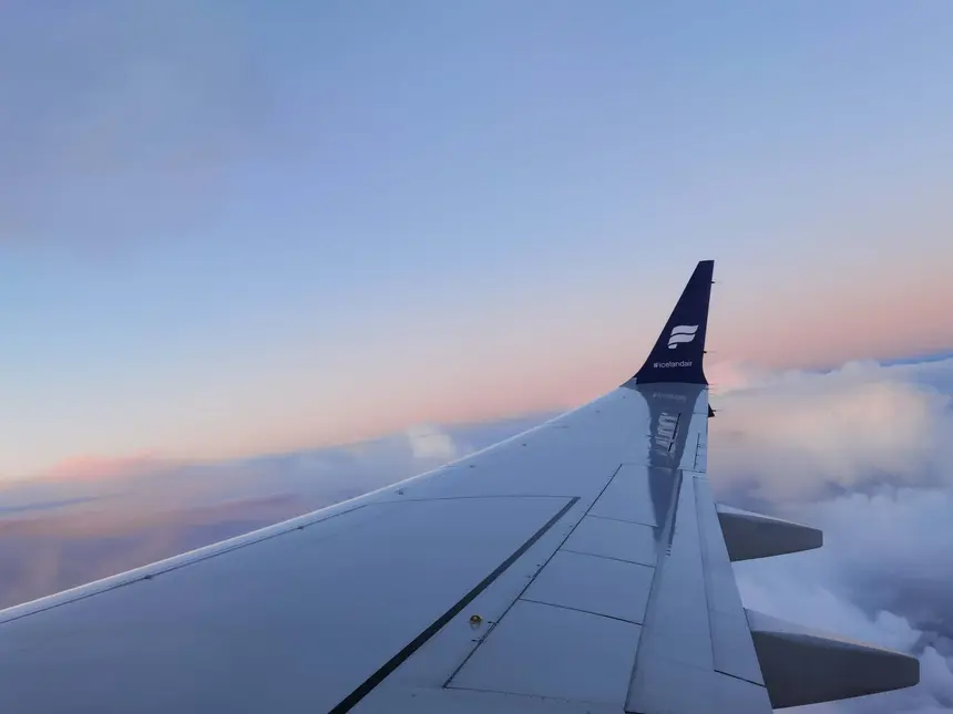 Tragfläche der Icelandair-Maschine über rosafarbenen Wolken auf dem Flug nach Keflavík