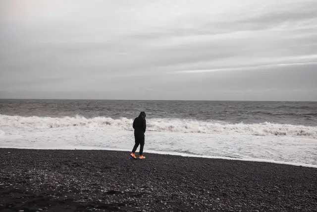 Spaziergang an der Brandungskante des schwarzen Strands von Reynisfjara