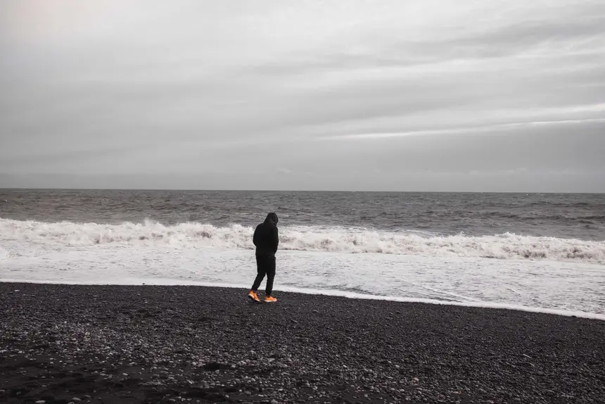 Spaziergang mit sicherem Abstand zur Brandungskante am schwarzen Strand von Reynisfjara