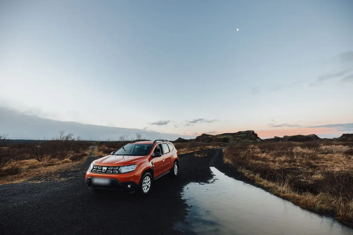 Auto auf einer einsamen Schotterstraße in Island in der Abenddämmerung