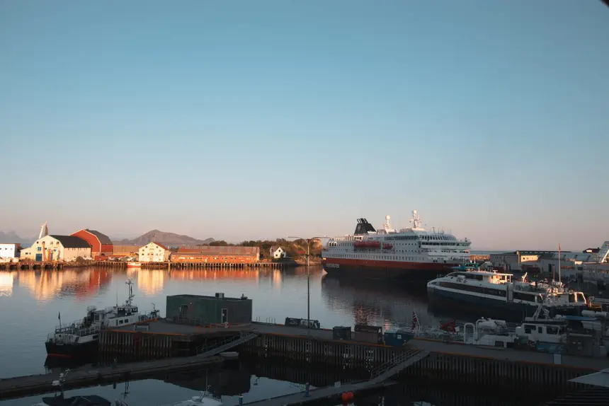Das Hurtigruten-Schiff liegt im Abendlicht am Kai von Stamsund auf den Lofoten