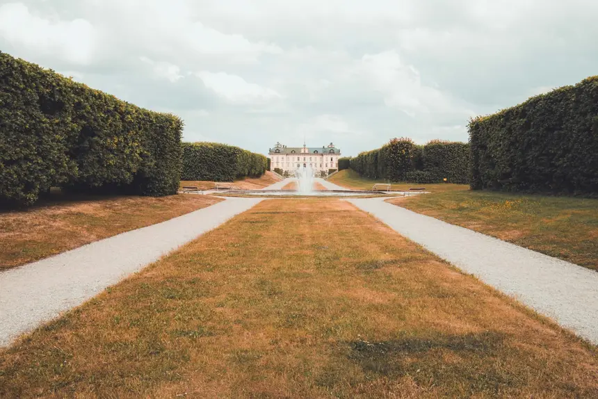 Barockgarten von Schloss Drottningholm mit Fontäne und geschnittenen Hecken