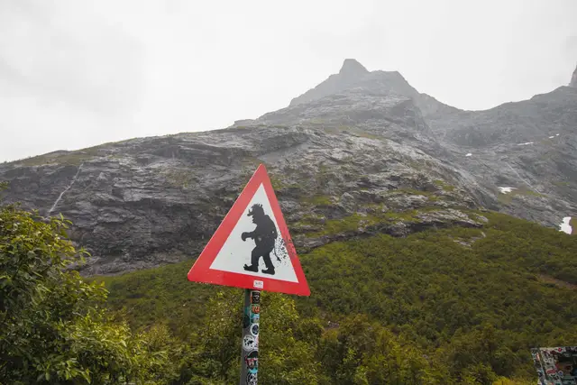 Troll-Warnschild vor der Felswand am Trollstigen